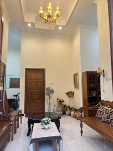 a living room with a table and a chandelier at Rama Shinta Keragilan Residence in Timuran