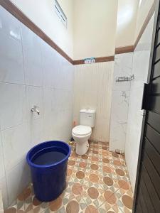 a bathroom with a toilet and a blue bucket at Rama Shinta Keragilan Residence in Timuran +10 photos