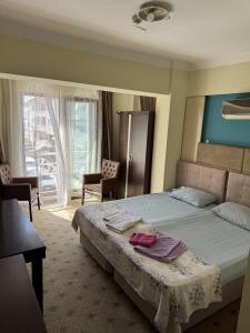 een slaapkamer met een bed met twee handdoeken erop bij Alya otel in Burdur