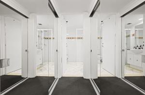 ein Badezimmer mit weißen Wänden und Glastüren in der Unterkunft The Relaxation CBD w Parking Desk Gym Pool in Sydney