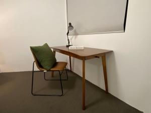 ein Schreibtisch mit einem grünen Kissen und einem Stuhl in der Unterkunft The Relaxation CBD w Parking Desk Gym Pool in Sydney + 13 Fotos