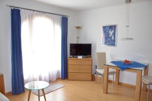 Una sala de estar con una mesa y un televisor. en Chardun, en Celerina