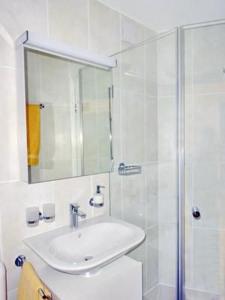 Un baño blanco con lavabo y ducha. en Chardun, en Celerina