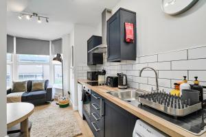 a kitchen with a sink and a living room at Kendal Lane Apartments in Central Station