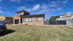 una casa de ladrillo con una cerca y un patio en Hello Home Struisbaai, en Struisbaai