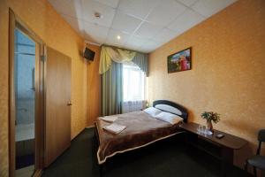 ブリャンスクにあるHotel Parusのベッドと窓が備わるホテルルーム