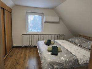 een slaapkamer met een bed met twee kussens erop bij Apartmán Zelený dom 43 in Banská Štiavnica