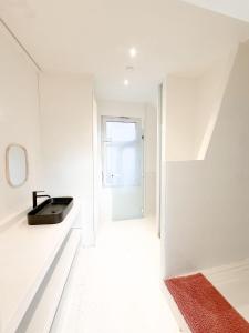a white hallway with a sink and a mirror at Le FauBourg Suites in Antwerp +51 photos