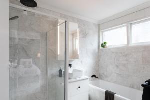 une salle de bain avec une douche, une baignoire et un lavabo dans l'établissement Highlands Heart Cottage, à Bowral 33 autres photos