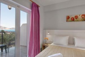 a bedroom with a bed and a large window at Armonia Hotel by Zante Plaza in Laganas