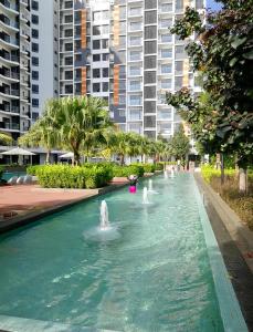 a fountain in a park with tall buildings in the background at Timurbay Residence Resort Style in Kuantan