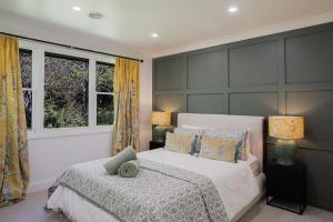 une chambre avec un grand lit et deux fenêtres dans l'établissement Highlands Heart Cottage, à Bowral