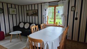 a living room with a table and chairs and a couch at Kilsborgs Gård - Lakehouse in Svanskog