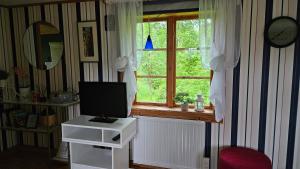 a room with a window and a television on a table at Kilsborgs Gård - Lakehouse in Svanskog
