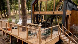 a house with a deck with chairs and a tree at Ecolodge de la Palombiere in Saint-Clar