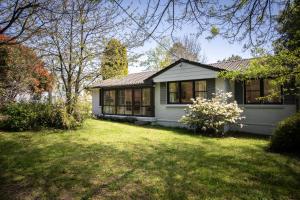 une maison blanche avec une cour devant elle dans l'établissement Highlands Heart Cottage, à Bowral