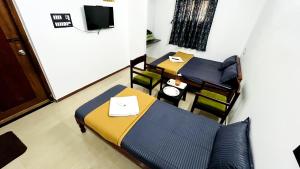 een kleine kamer met een bed en een tafel en stoelen bij Le Beach Villa, Luxurious Stay Opposite Auroville Beach, ECR Road in Kuilapayam