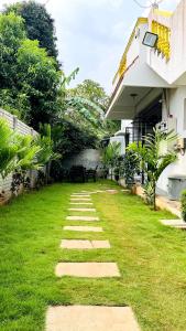 een tuin met stapstenen voor een huis bij Le Beach Villa, Luxurious Stay Opposite Auroville Beach, ECR Road in Kuilapayam