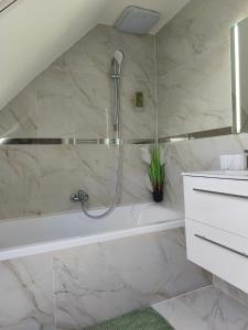 een badkamer met douche en ligbad bij Apartmán Zelený dom 43 in Banská Štiavnica