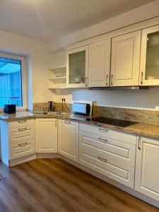 a kitchen with white cabinets and a sink at Schöne Wohnung 1 in Buchholz in der Nordheide +10 photos