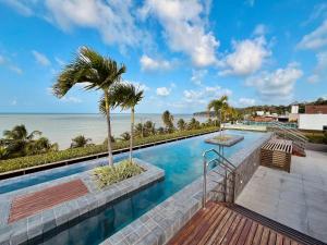 a swimming pool with a view of the ocean at Unity - Flat Premium à Beira-Mar em Cabo Branco in João Pessoa