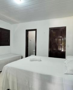 een witte slaapkamer met 2 bedden en een badkamer bij Pousada Solar de Maria e Hostel Feminino in Pipa +30 foto's