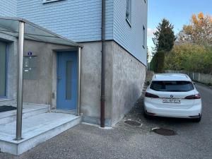 a white car parked in front of a building at Gemütliche Souterrainwohnung mit gratis Parkplatz in St. Gallen