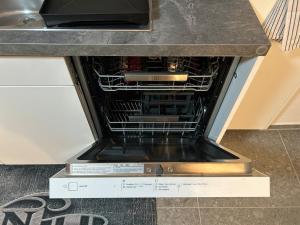 an open dishwasher in a counter in a kitchen at Gemütliche Souterrainwohnung mit gratis Parkplatz in St. Gallen +10 photos
