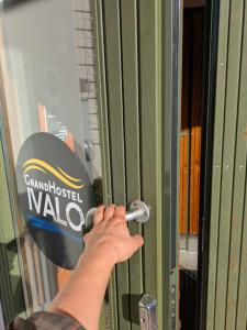 a person is unlocking a door with a key at Grand Hostel Ivalo in Ivalo