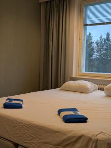 two towels are sitting on top of a bed at Grand Hostel Ivalo in Ivalo