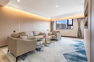 a living room with couches and a table at Tiancheng Hotel Liangjiahe Metro Station Branch in Kunming