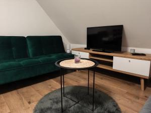 een woonkamer met een groene bank en een salontafel bij Apartmán Zelený dom 43 in Banská Štiavnica