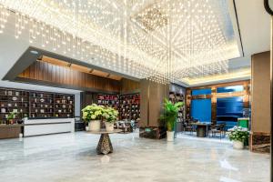 a lobby with a large ceiling with lights at Tiancheng Hotel Liangjiahe Metro Station Branch in Kunming