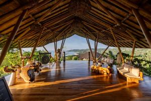 a large wooden deck with couches and a large roof at Ketanu Bamboo Lodge Sumba in Praikalogu