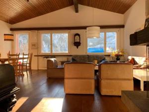 a living room with a couch and a table and chairs at Casa Caglina in Disentis