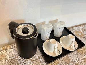 a coffee maker and two cups on a tray at Ali House Patong in Patong Beach