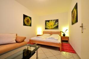 a small bedroom with a bed and a couch at AJO Apartments - Alte Donau Garden Flat - Self-Check-in in Vienna