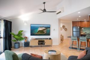 ein Wohnzimmer mit Sofa und Tisch in der Unterkunft Bella Isola in Airlie Beach