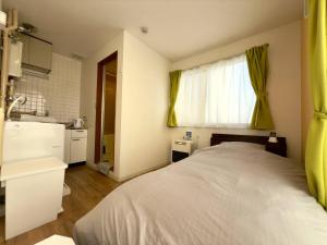 a bedroom with a bed and a sink and a kitchen at 2-6大通駅まで地下鉄で4駅の場所で美室のリフォーム済みアパートメント in Sapporo