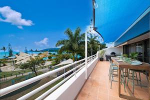 ein Balkon mit Tisch und Stühlen und Blick auf das Meer in der Unterkunft Bella Isola in Airlie Beach