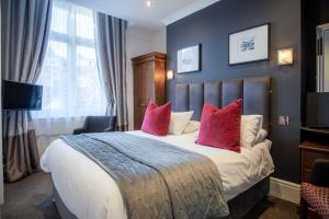 a bedroom with a large bed with pink pillows at The Helaina in Scarborough +43 photos