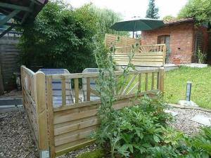 a wooden fence with an umbrella in a yard at Ferienwohnung Lotti in Brotterode-Trusetal