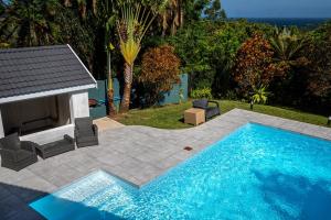 a swimming pool in a yard next to a patio at The Lookout Guesthouse in Uvongo Beach