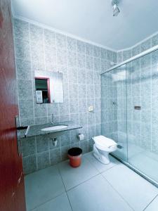 a bathroom with a toilet and a sink and a shower at Colonial Hotel in Campo Grande +24 photos