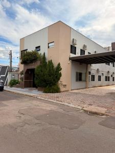 a large white building on the side of a street at Colonial Hotel in Campo Grande