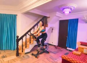 PūrnānkuppamCeleste Luxury Bungalow的一名女子骑着健身自行车下楼梯。