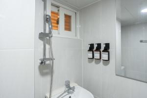 a white bathroom with a sink and a mirror at stay105행궁 in Suwon +55 photos