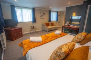 a bedroom with a large bed with orange sheets at Bells Hotel in Coleford