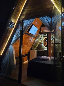 een slaapkamer met een bed in een kamer met houten plafonds bij Chale suite privativo cafe e hidro in Sao Jose do Rio Preto