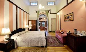 a bedroom with a large bed and a couch at Belvedere Palace Nainital in Nainital